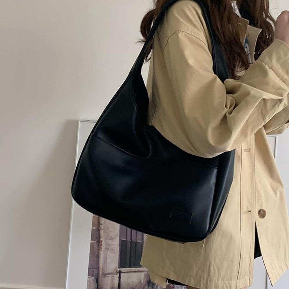 Fiora shoulder bag in black, worn with beige jacket