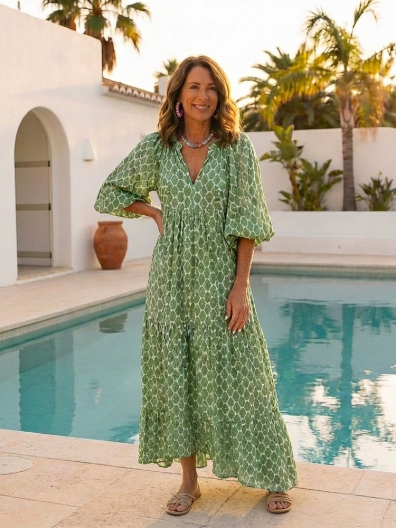 Apolline patterned midi dress in green, worn poolside at sunset