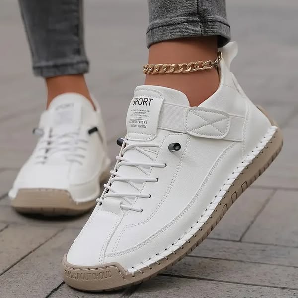 Thessaly supportive sneakers in white with tan sole, worn walking view