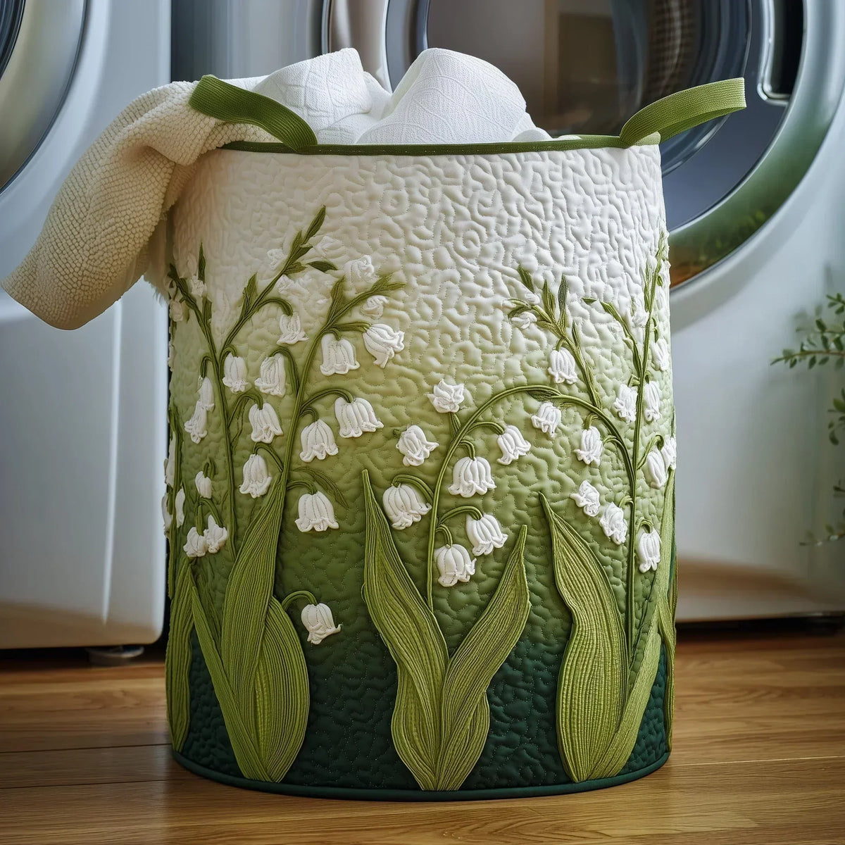 Cora hand-quilted laundry basket with lily-of-the-valley design in green and cream