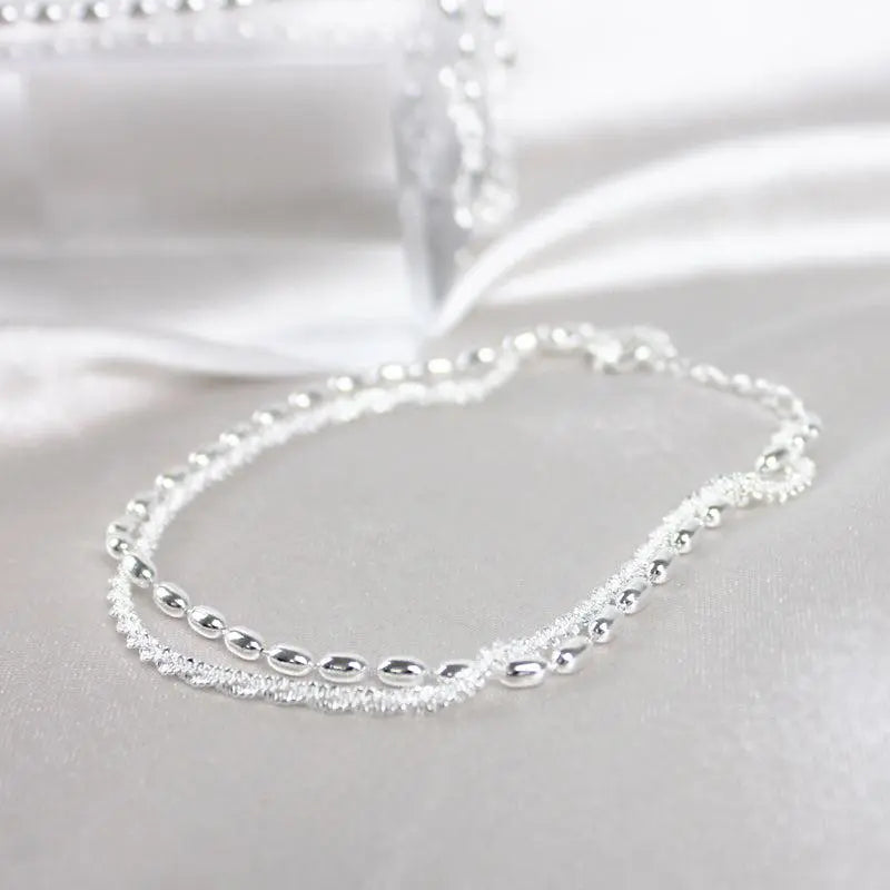 Silver bracelet set showing bead and zirconia strands, flat view