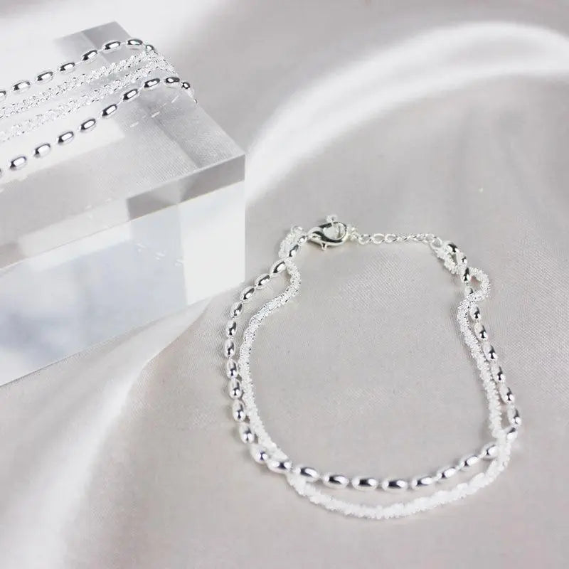 Silver bracelet set with clasp fastening, flat view