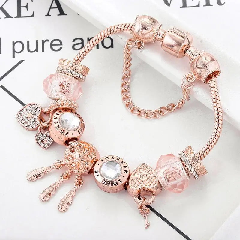 Rose gold dreamcatcher charm bracelet with pink beads and crystal hearts, close-up view