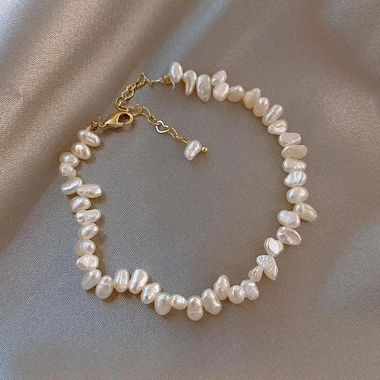 Classic pearl bracelet in white, flat view on soft cream backdrop
