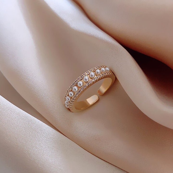 Gold and pearl ring on blush silk, angled view of the pearl rows