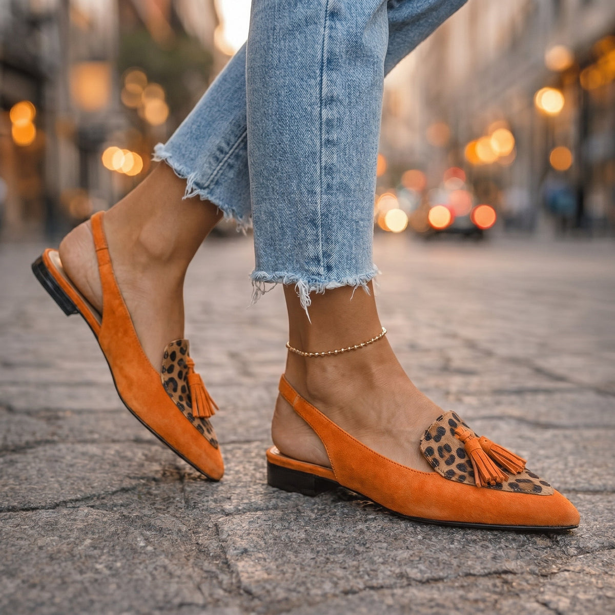 Arabella tassel loafers in orange leopard print, walking view with cropped jeans