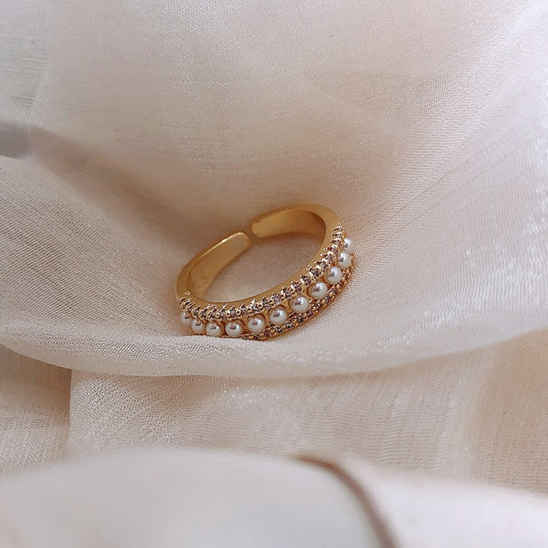 Gold and pearl ring on cream fabric, side view of double pearl rows