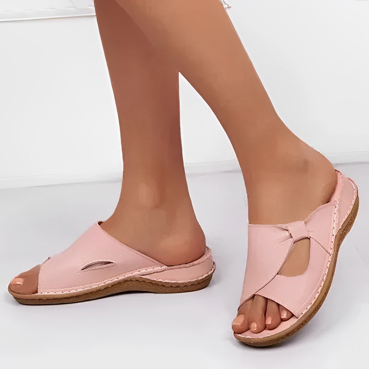 Slim slip-on sandals in pink with cut-out detail, worn walking view