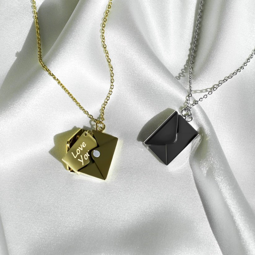 Gold envelope necklace opened to show Love You tag beside silver version