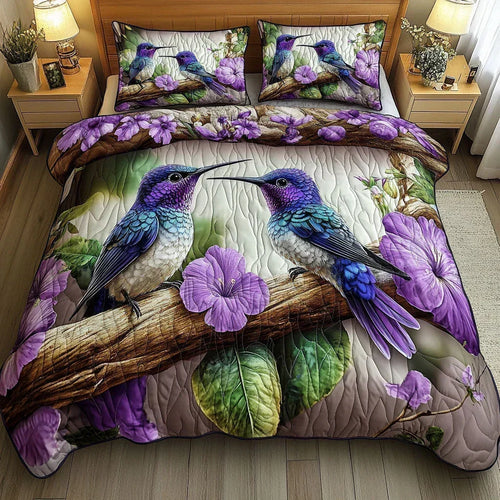 Bird Sanctuary quilted bedding set with purple hummingbirds and flowers, styled on a bed