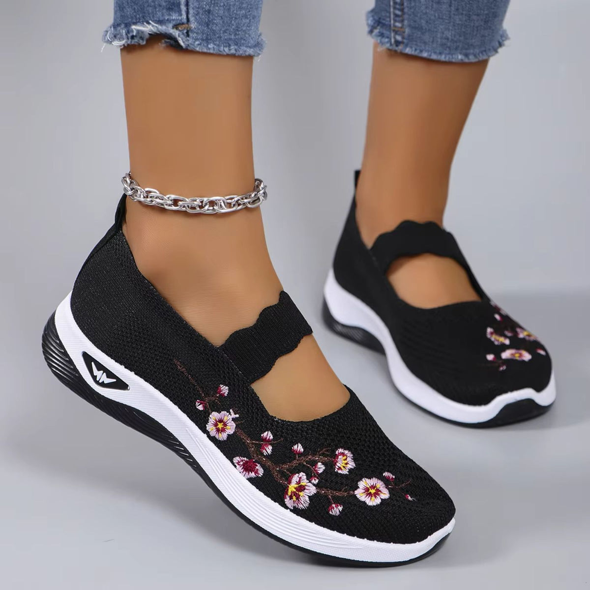 Leona slip-on orthopaedic shoes in black with floral embroidery, worn front view