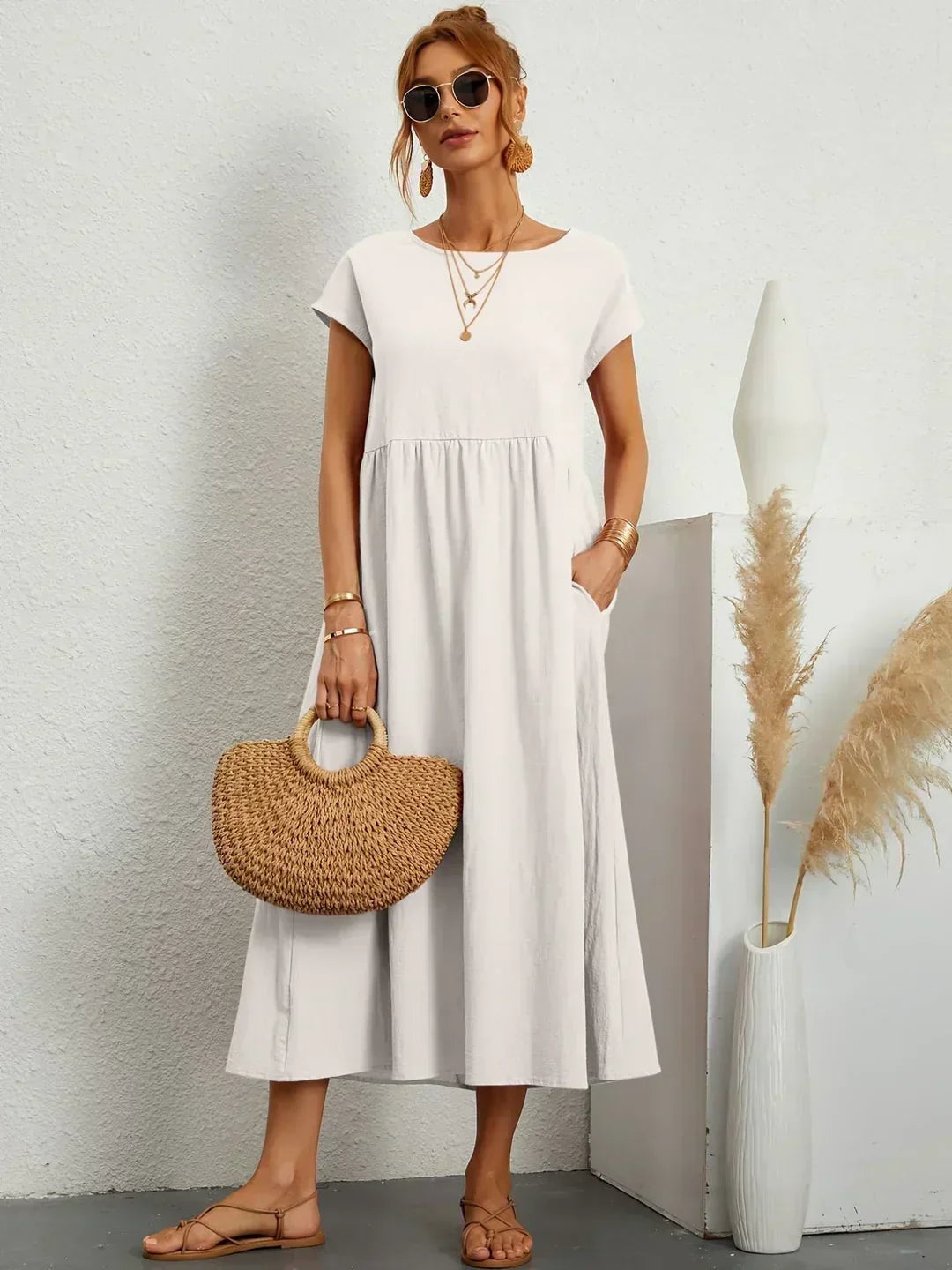 Gabrielle flowing midi dress in white, full-length front view with straw bag