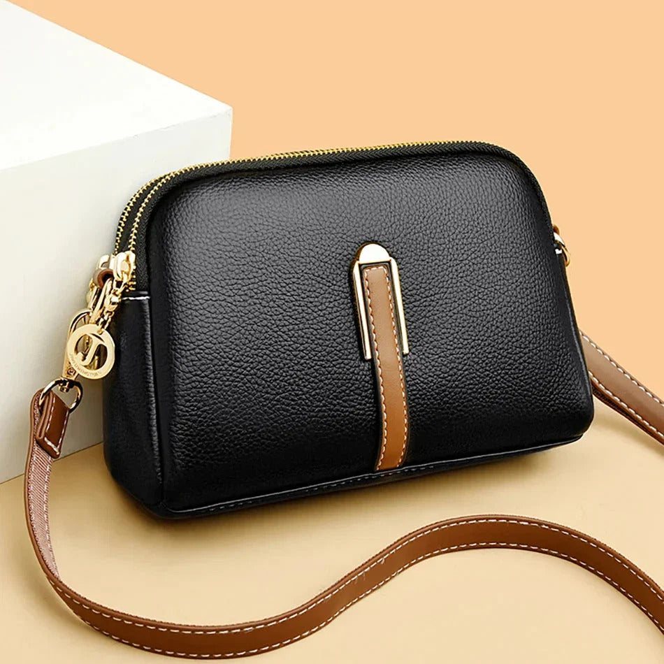 Emanuela crossbody bag in black with tan strap, front view