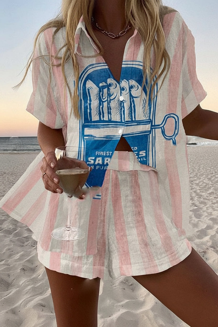 Sardegna co-ord set in pink and white stripes with blue sardine print, worn on the beach