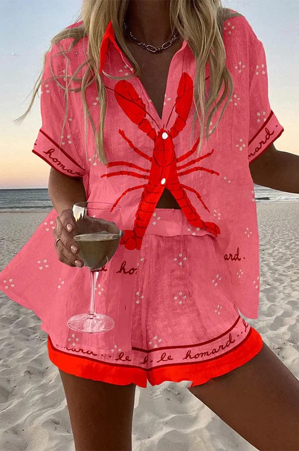 Riviera summer co-ord set in dusty pink with red lobster print, worn on the beach