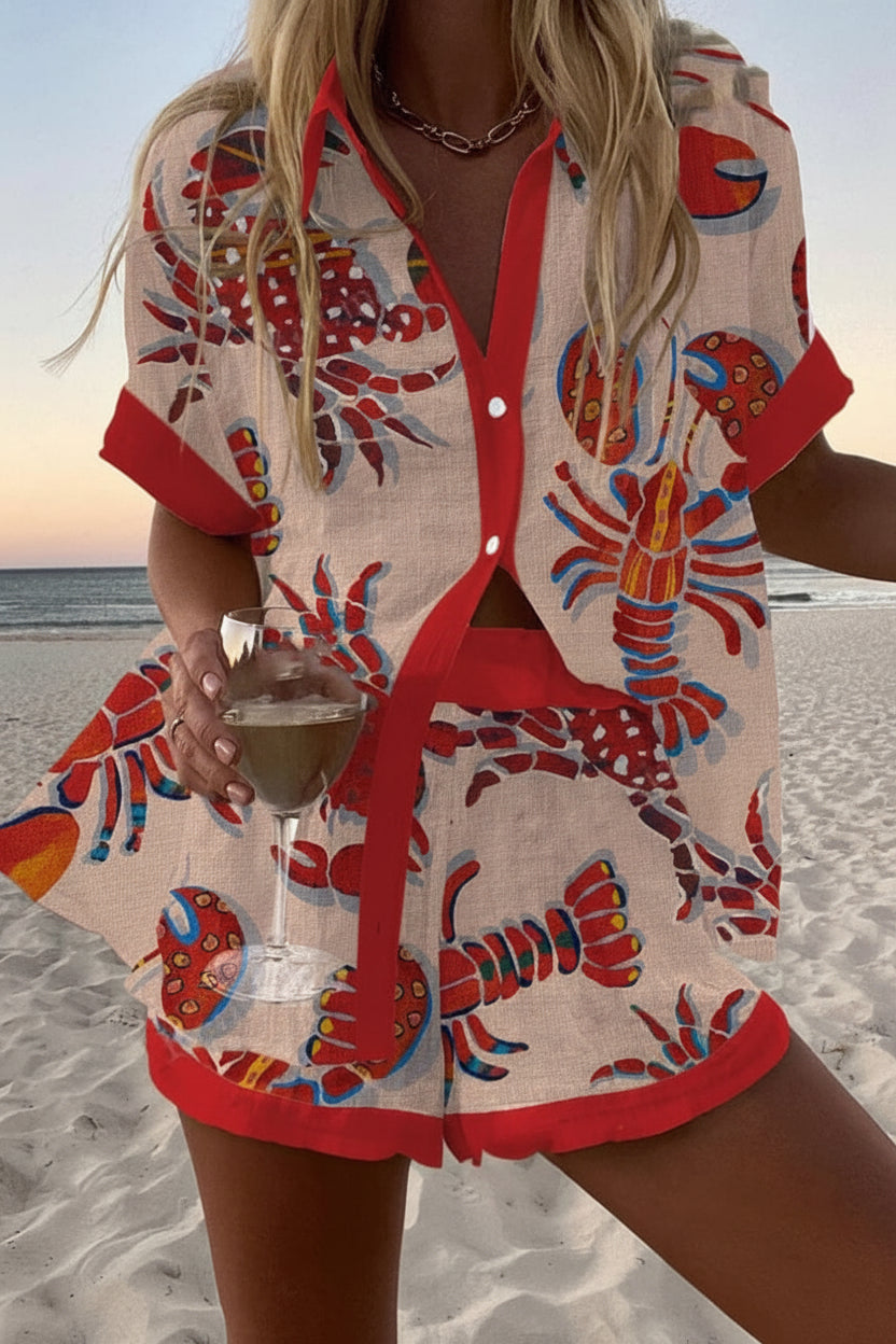 Monaco summer co-ord set in cream with red lobster print, worn on the beach