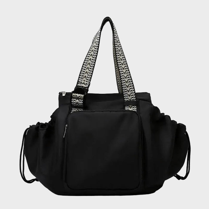 Ezra Pack Tote in black with patterned woven straps, front view