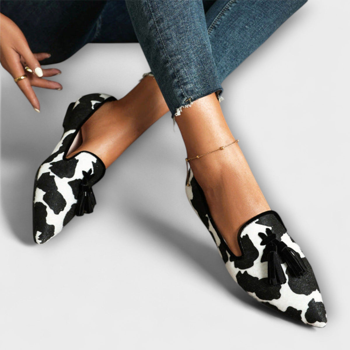 Lucia black animal print tassel loafers, side view worn with denim