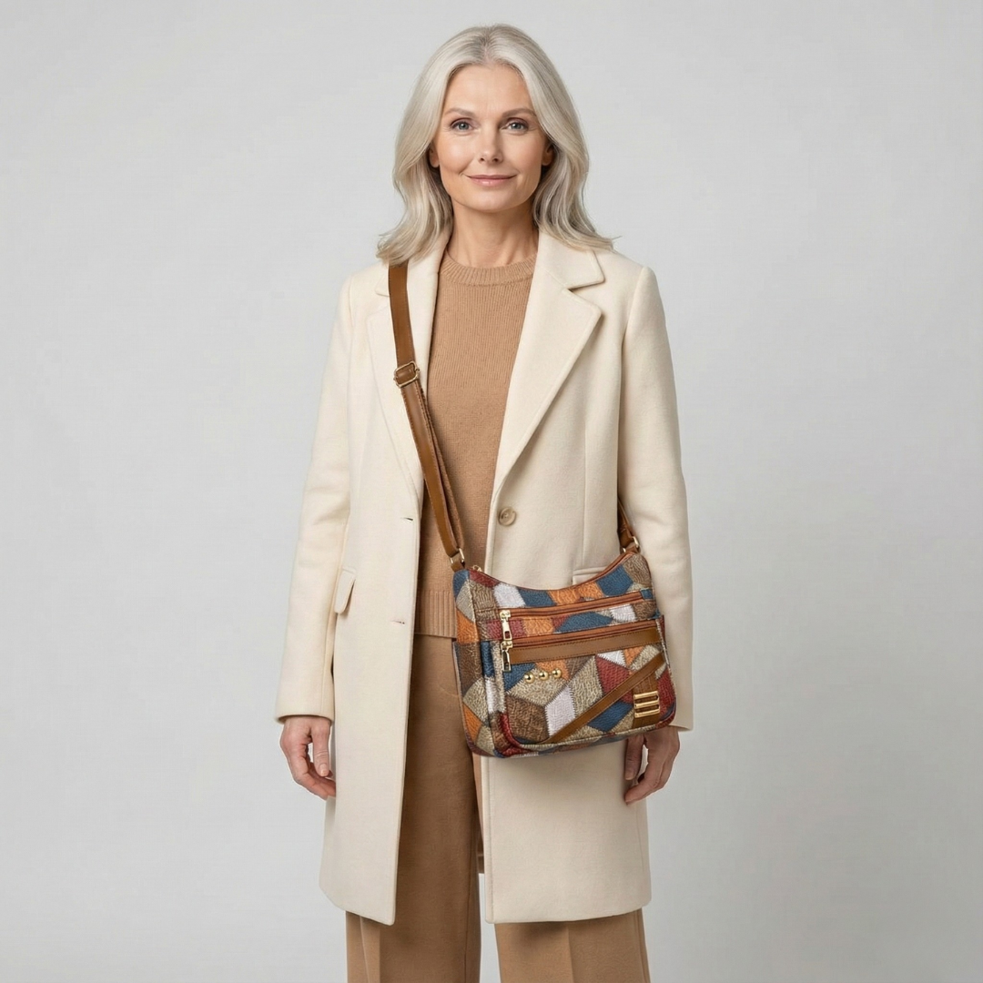 Maria patchwork shoulder bag worn crossbody with a cream coat