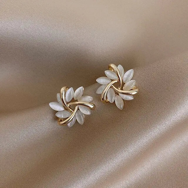Opal and gold petal stud earrings on cream satin