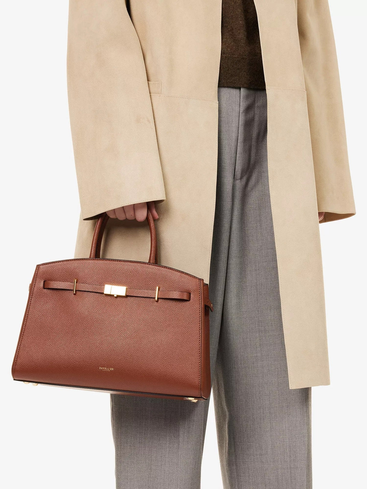 Amélisse midi handbag in brown carried by hand with tailored trousers