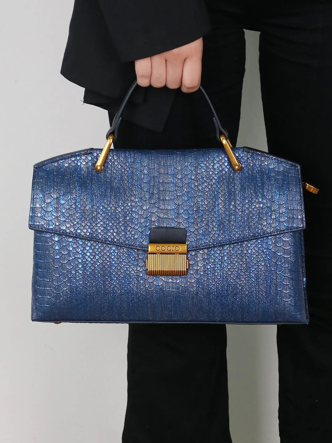 Selene python tote bag in royal blue, held by top handle