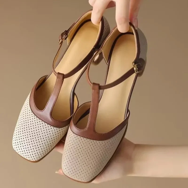 Genira mid-heel T-strap shoes in off-white, held to show buckle and block heel