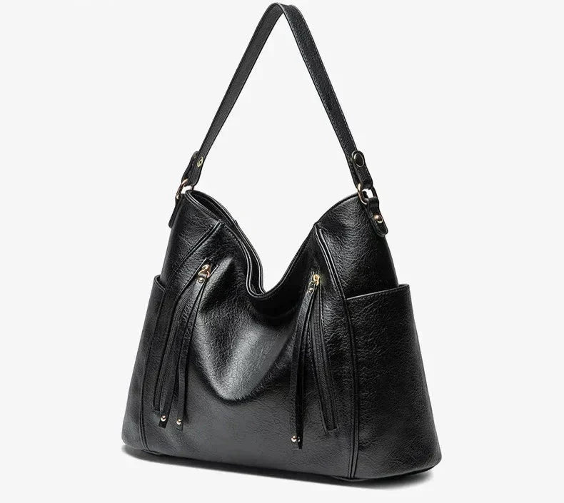 Calista luxe shoulder bag in black, angled view showing side pocket