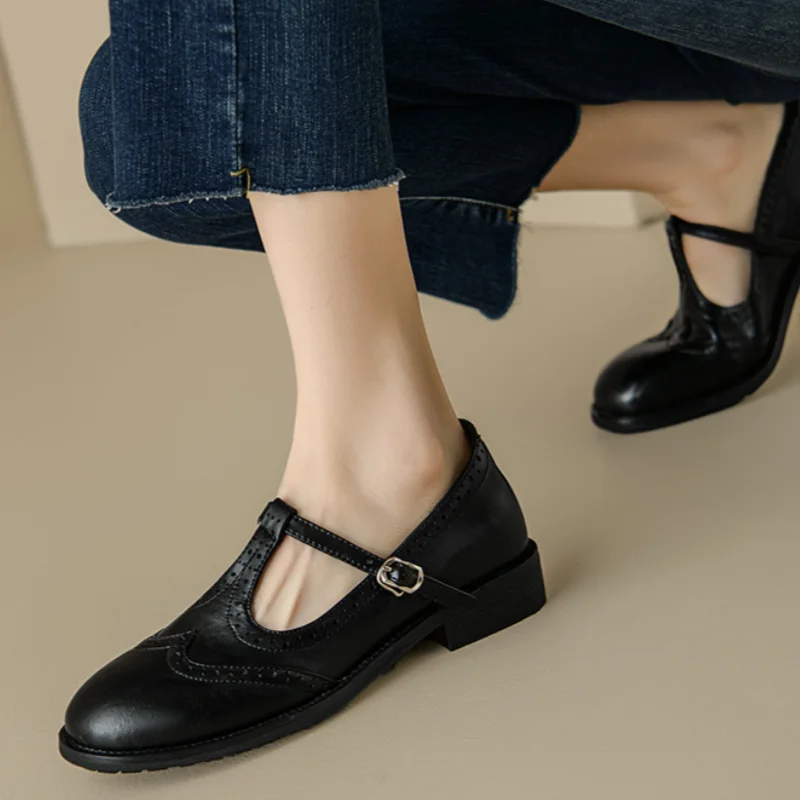 Miana T-strap Mary Janes in black, worn with cropped jeans side view