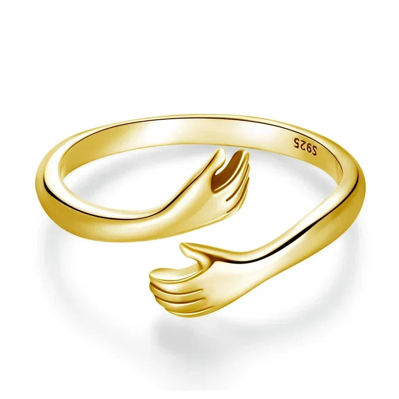 Hug hands minimalist ring in gold, close-up of embracing hands