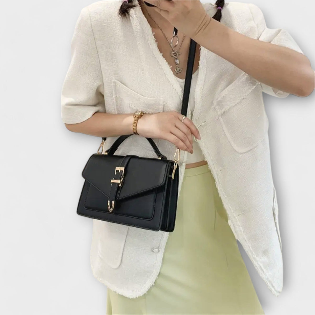 Olívia shoulder bag in black worn crossbody with cream jacket