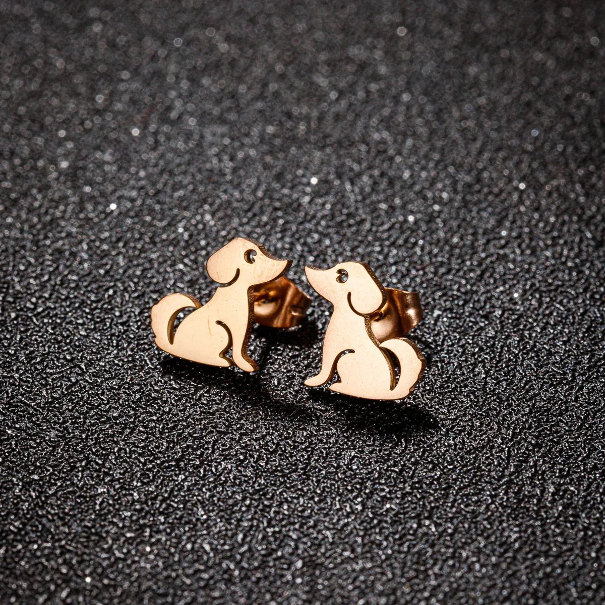 Rose-tone dog stud earrings shown side by side