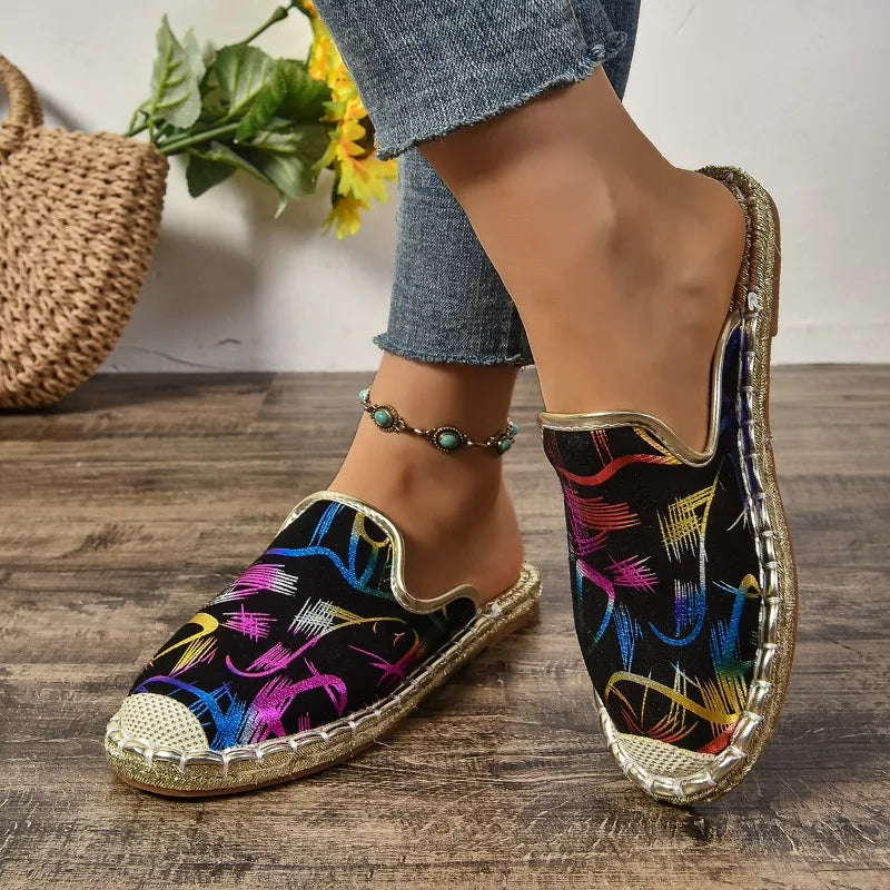 Slip-on flats in black multicoloured brushstroke print, worn side view