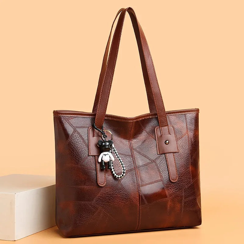 Susan classic vintage tote bag in brown, front angled view with bear keychain