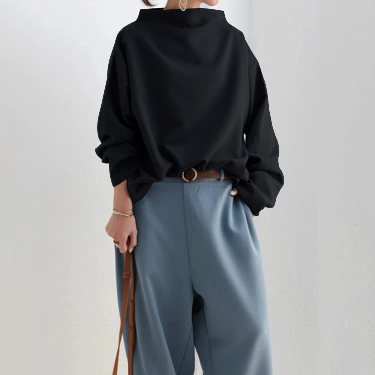 Elspeth high-neck casual top in black, styled tucked into blue trousers
