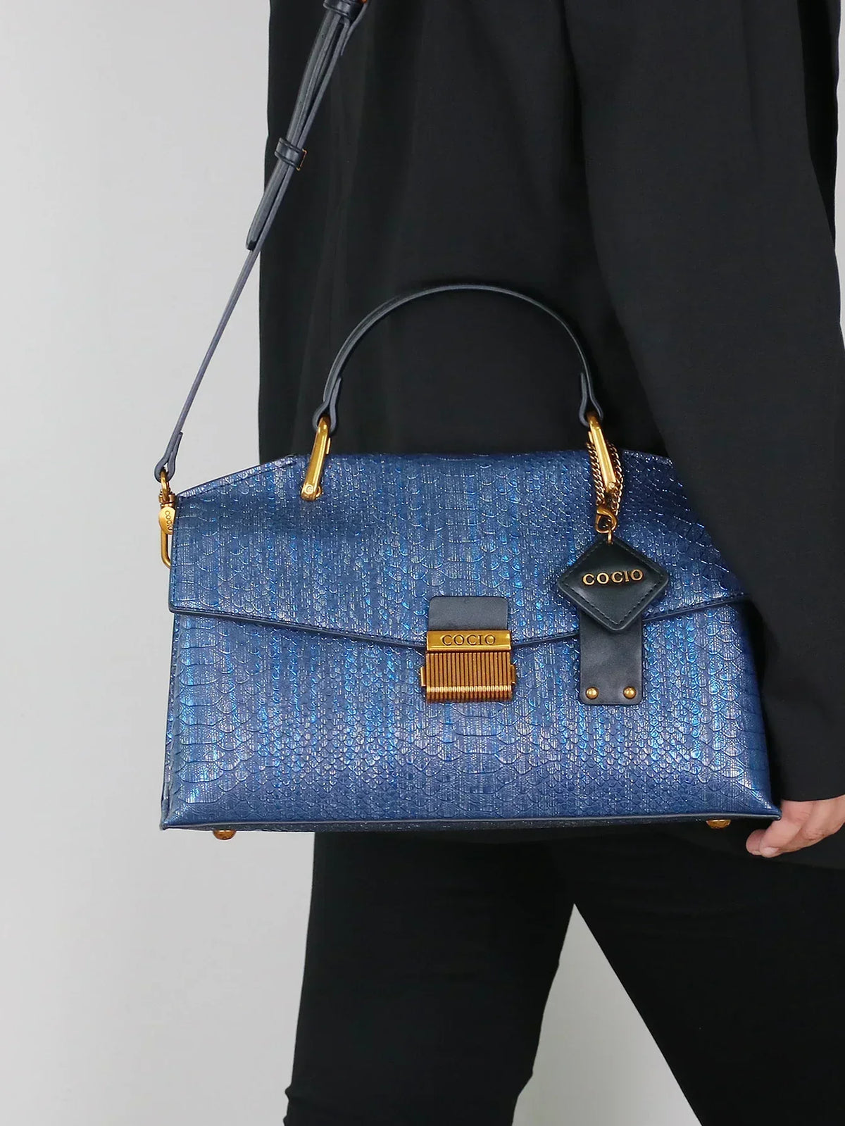 Selene python tote bag in royal blue worn crossbody with black outfit