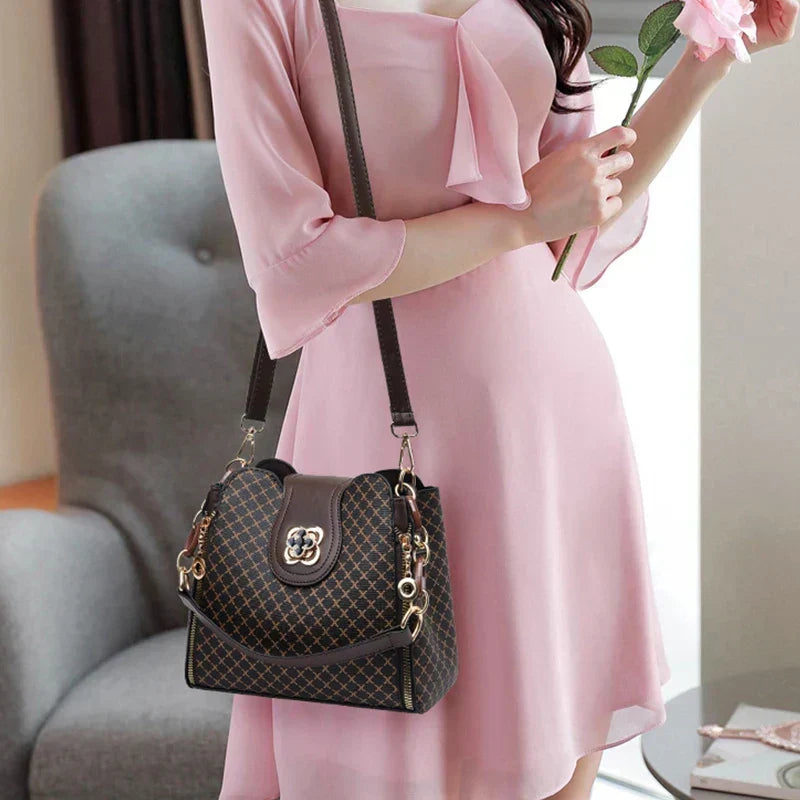Marjorie charm bag in coffee worn crossbody with a pink dress