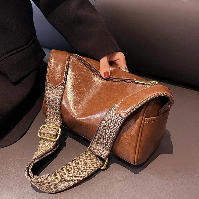 Florence crossbody bag in brown, close-up of zip and strap buckle