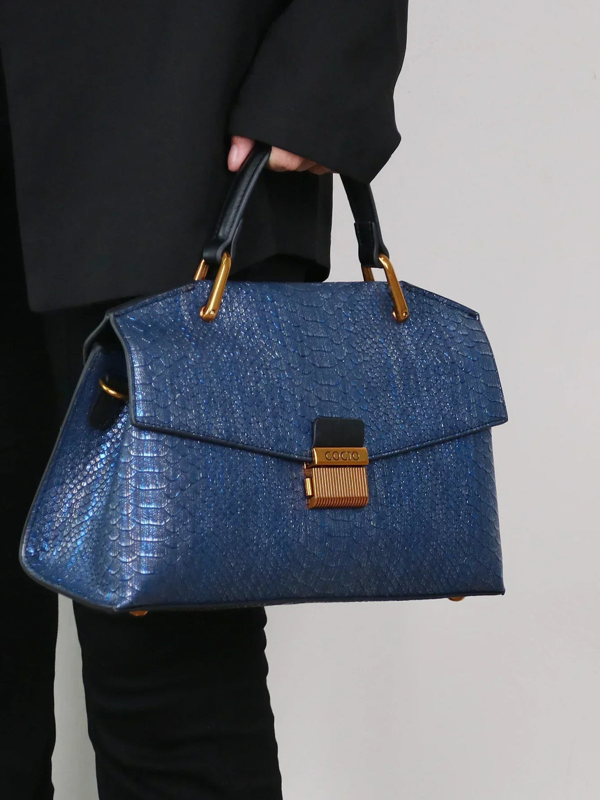 Selene python tote bag in royal blue, side angle carried by hand