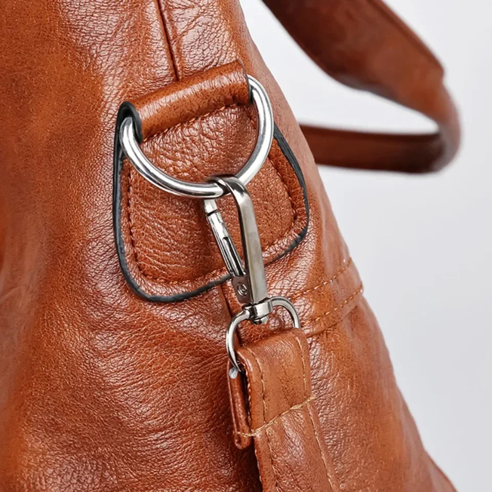 Close-up of retro tote bag strap ring and clip fastening in camel