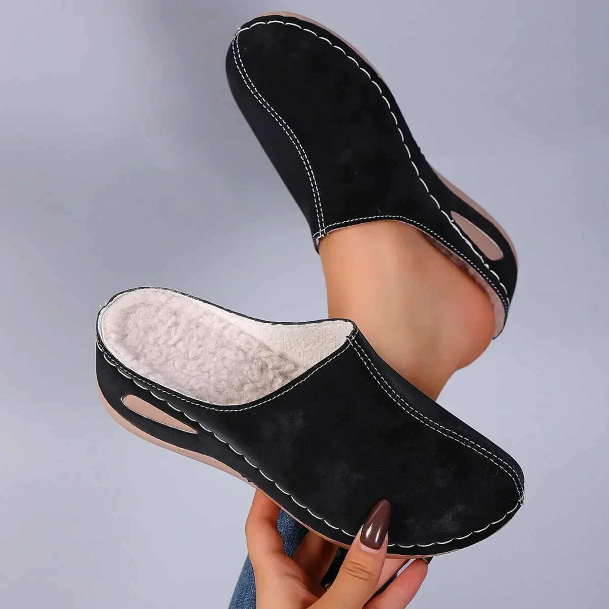 Sophie orthopaedic slippers in black, pair held to show soft footbed