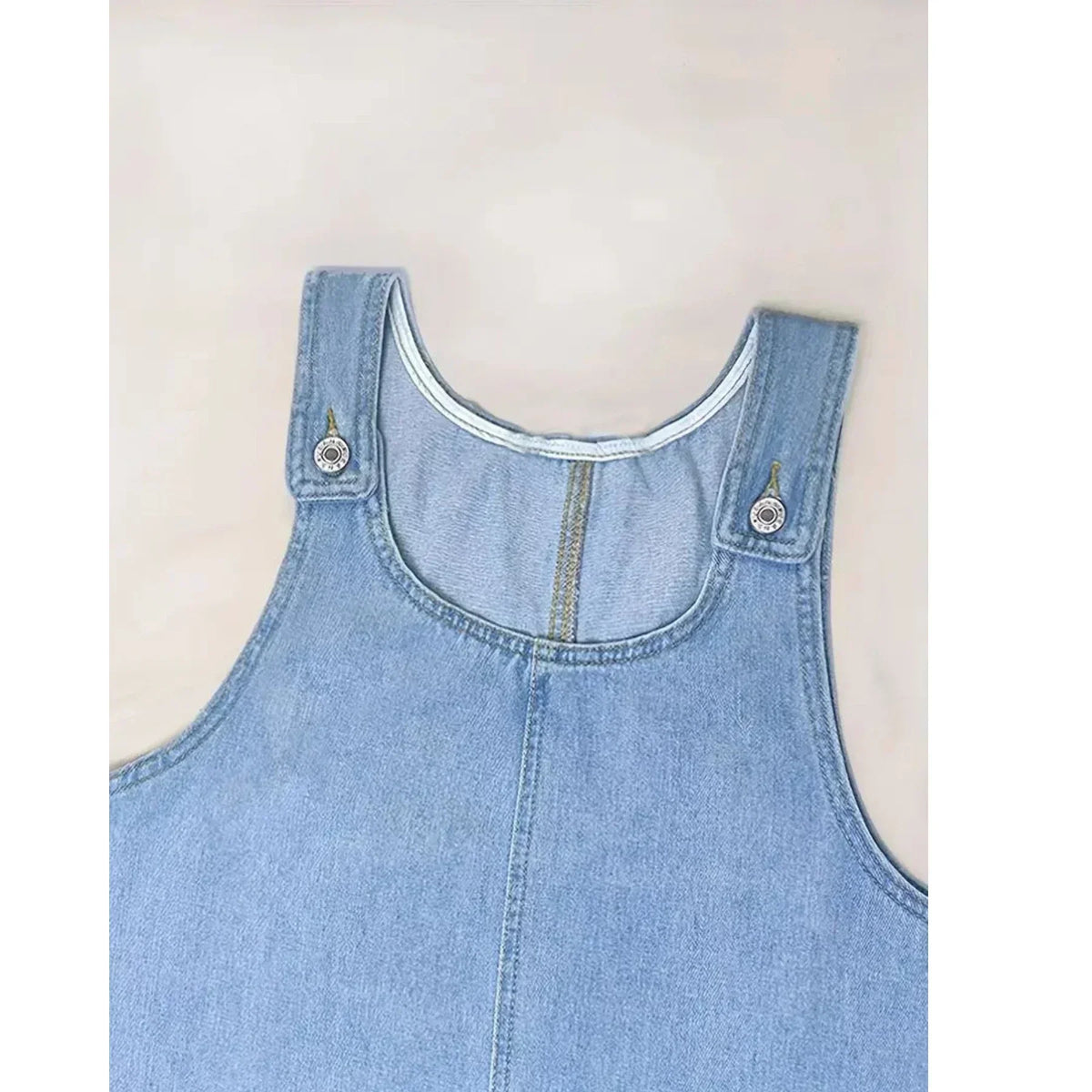 Saylor denim dress detail showing scoop neck and button-tab straps