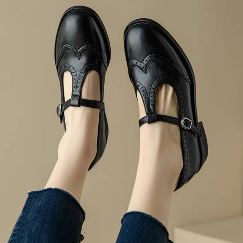Miana T-strap Mary Janes in black, worn top view with buckle strap