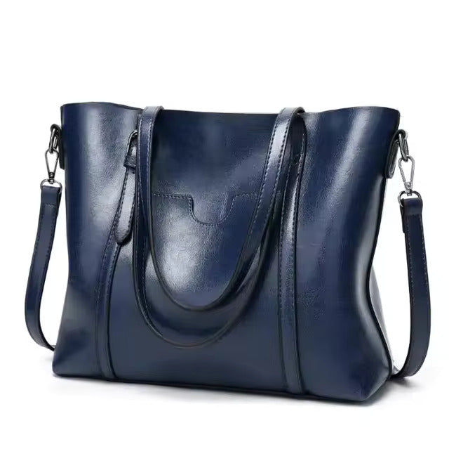 Daphira sleek shoulder bag in blue, three-quarter view with strap