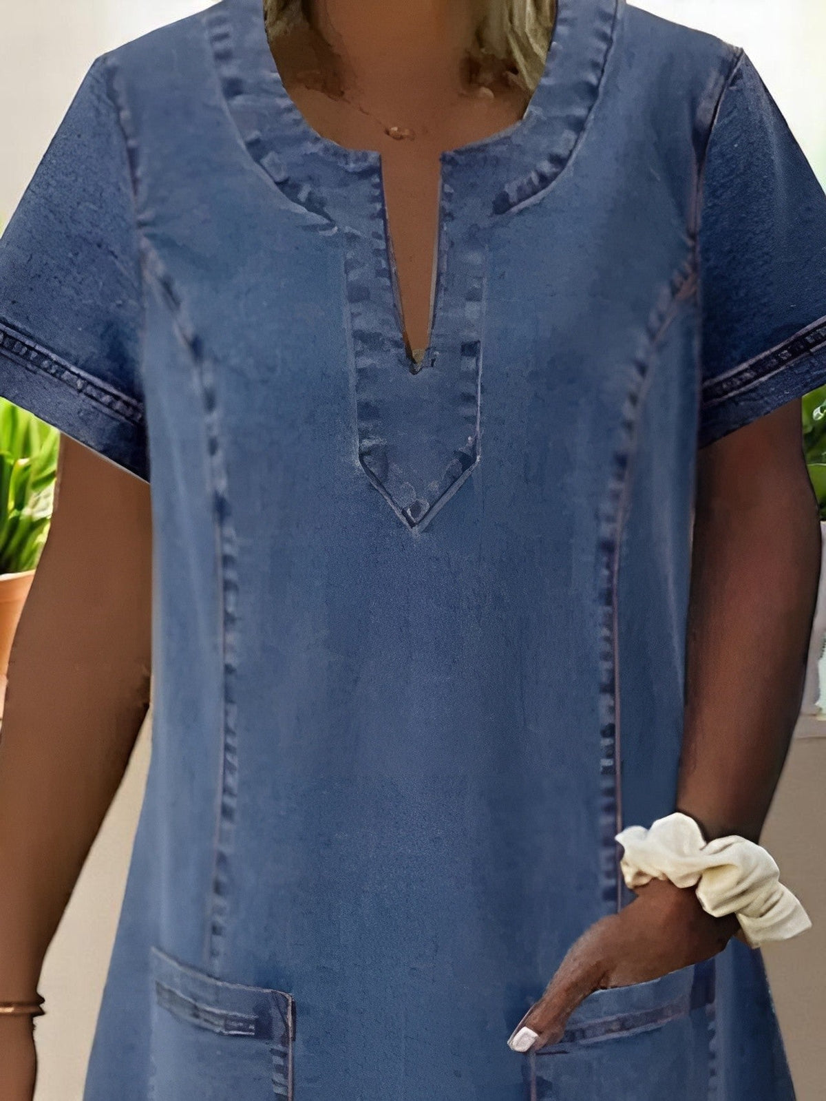 Sky denim dress in mid blue, close-up of notched neckline and stitching