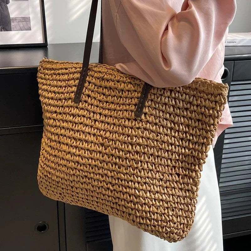 Large woven tote bag in brown carried on the shoulder