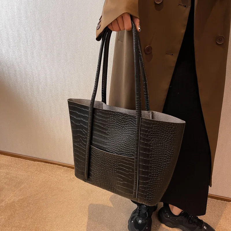 Sylvette croc shoulder bag in black, held by the handles