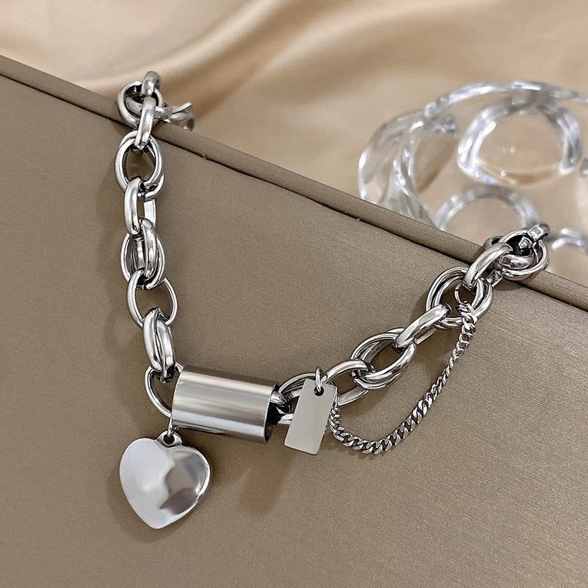 White gold chunky bracelet close-up with heart and tag charms