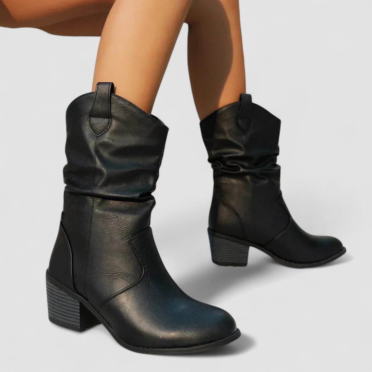 Eleanora slouch heeled boots in black, seated side view