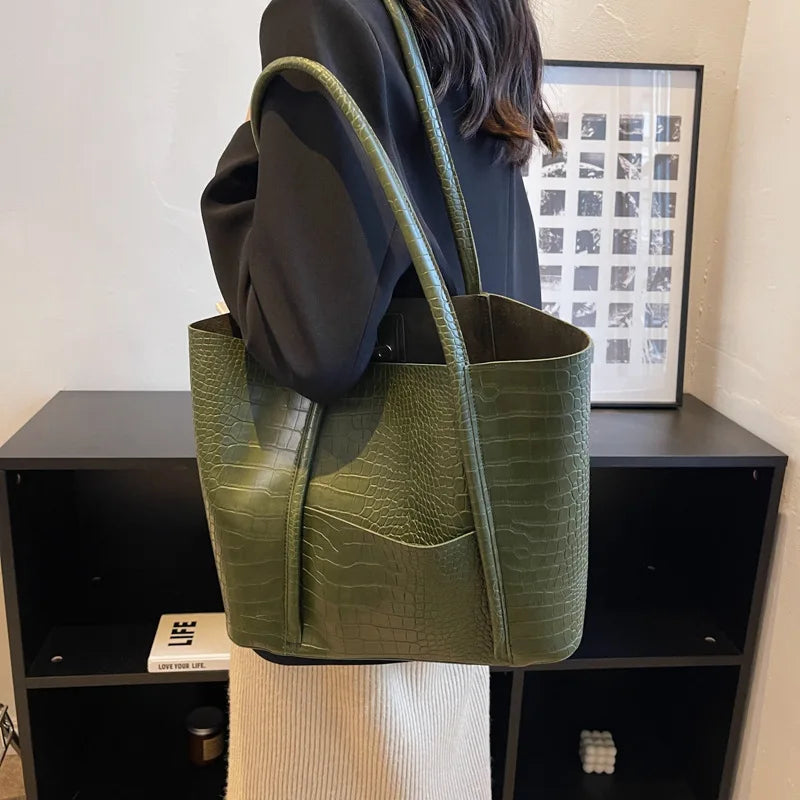 Sylvette croc shoulder bag in green, worn on the shoulder